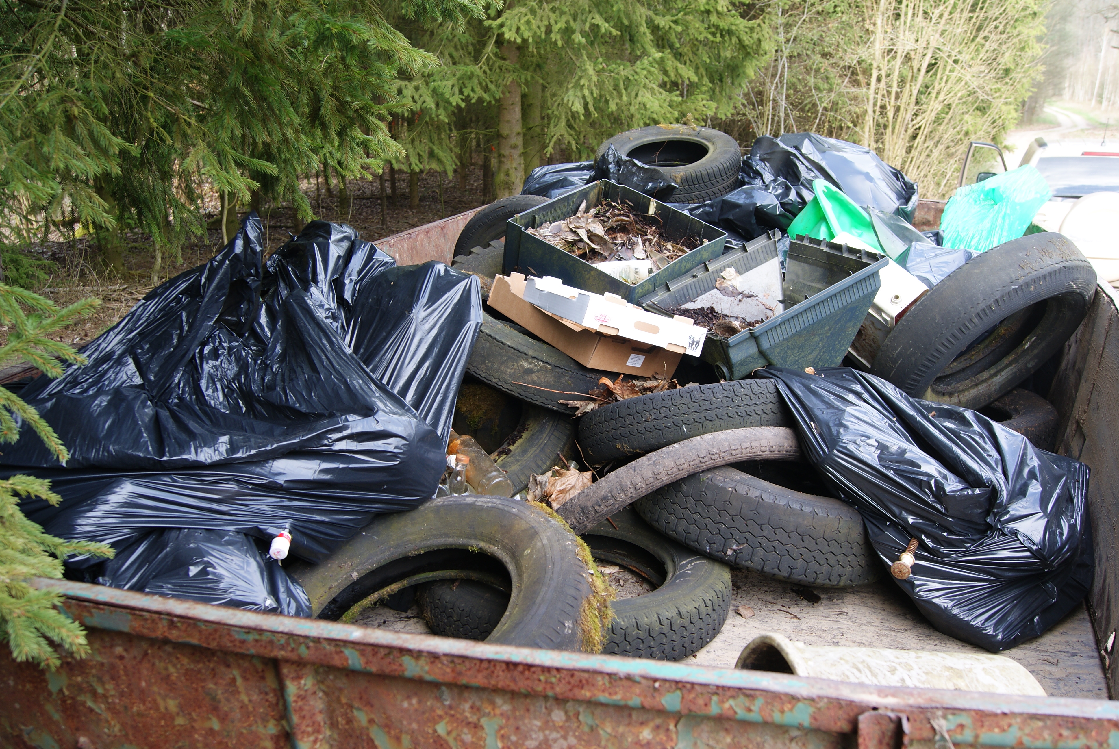 Zdjęcie przedstawia przyczepę pełną śmieci zebranych w lesie podczas Akcji